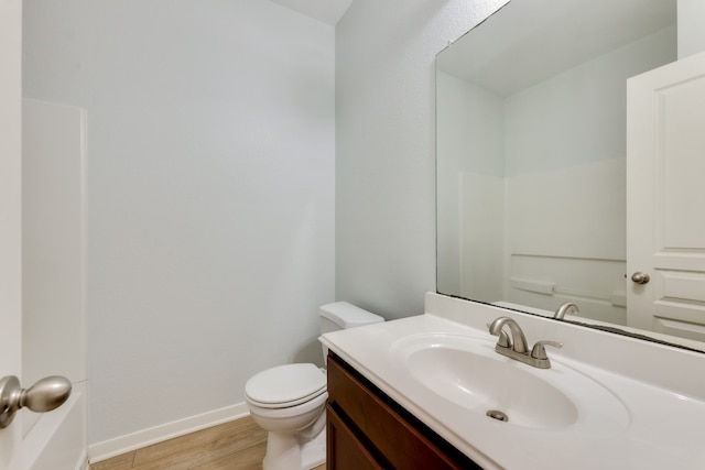 bathroom with wood-type flooring, vanity, and toilet