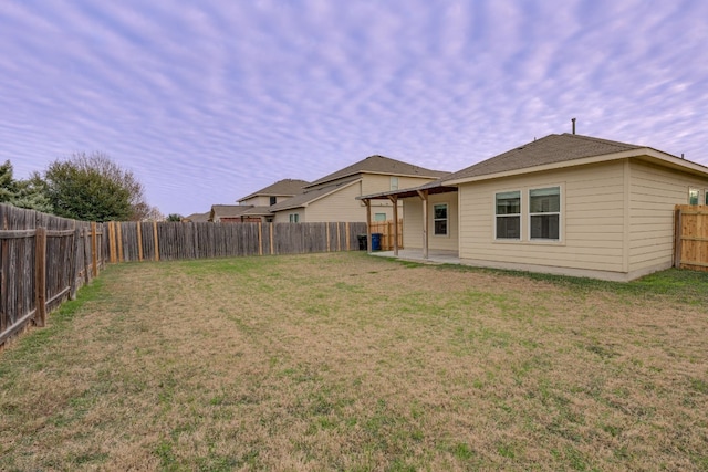 rear view of property featuring a lawn and a patio