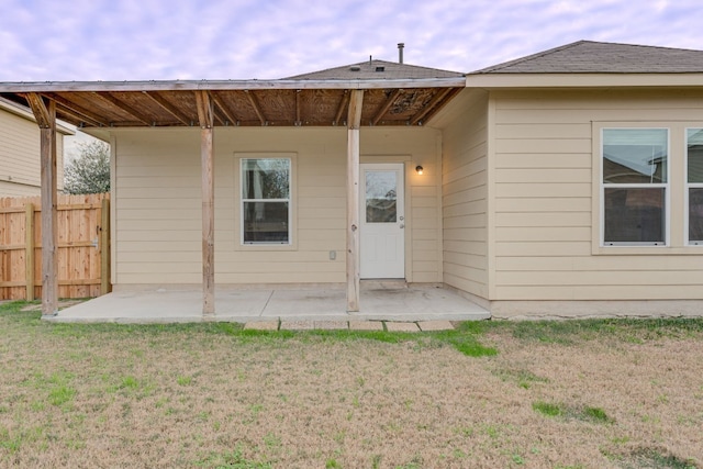 rear view of property featuring a yard and a patio area