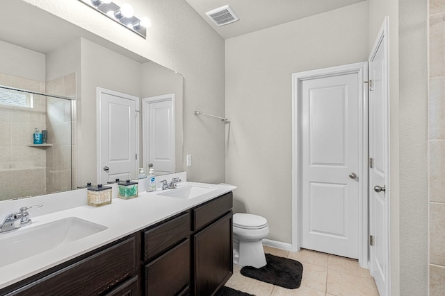 bathroom featuring tile patterned flooring, vanity, toilet, and walk in shower