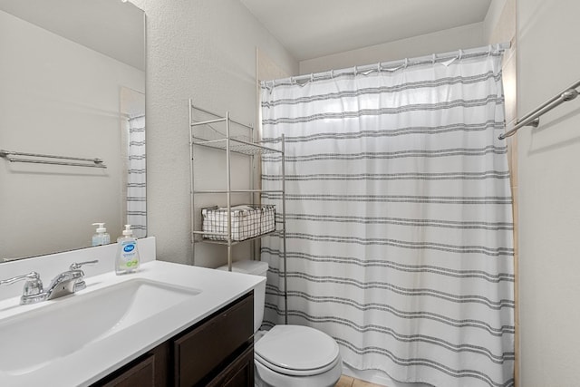 bathroom featuring walk in shower, vanity, and toilet