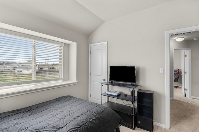 bedroom featuring light colored carpet and vaulted ceiling