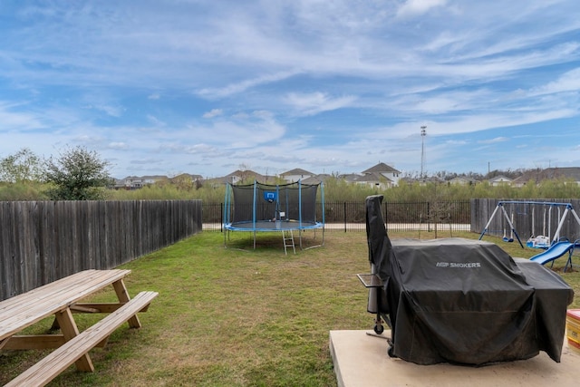 view of yard featuring a playground and a trampoline