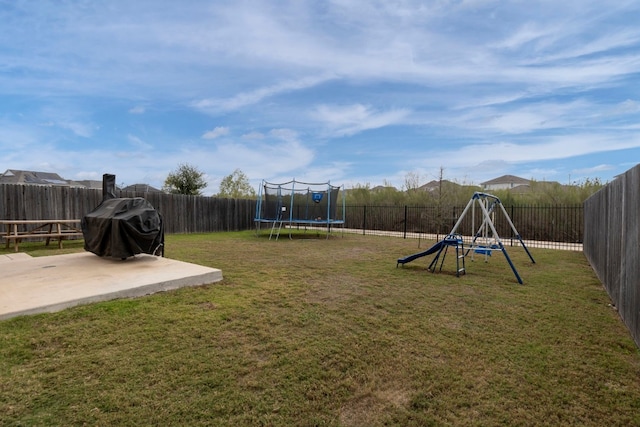 view of play area featuring a lawn, a patio area, and a trampoline