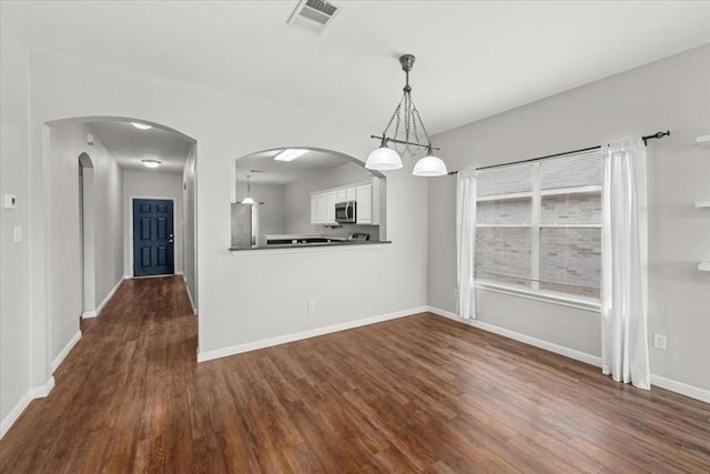 unfurnished dining area with a chandelier, dark hardwood / wood-style floors, and plenty of natural light