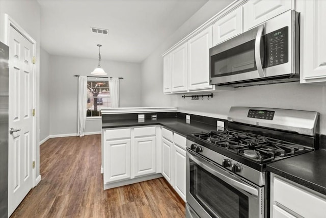 kitchen featuring white cabinetry, hanging light fixtures, stainless steel appliances, and dark hardwood / wood-style floors