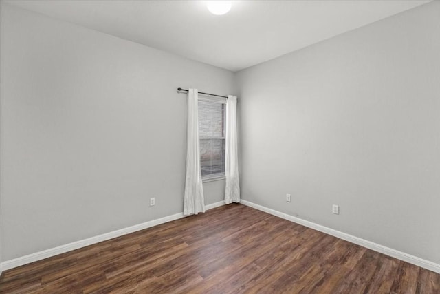 unfurnished room with dark wood-type flooring