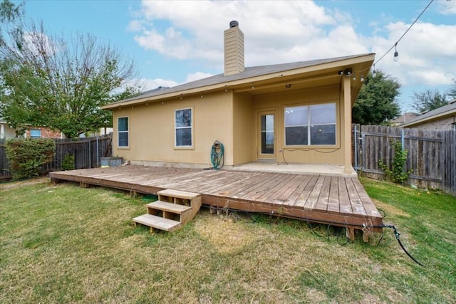 rear view of property with a yard and a deck