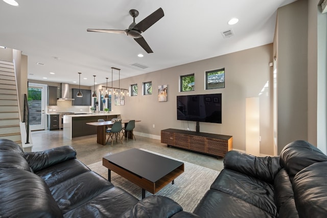 living room with ceiling fan and concrete flooring