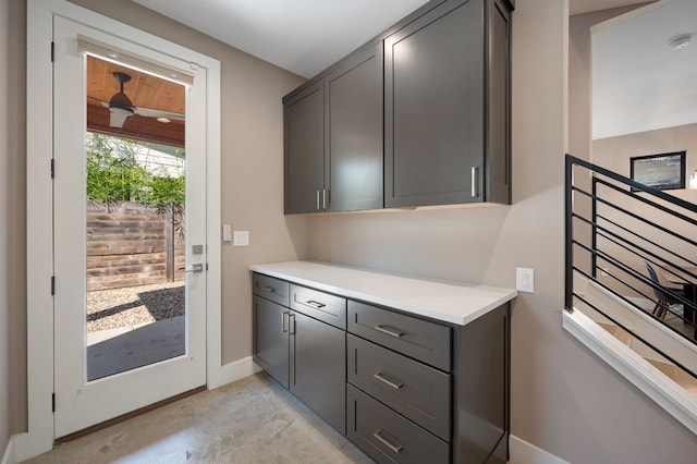 interior space with ceiling fan and gray cabinetry