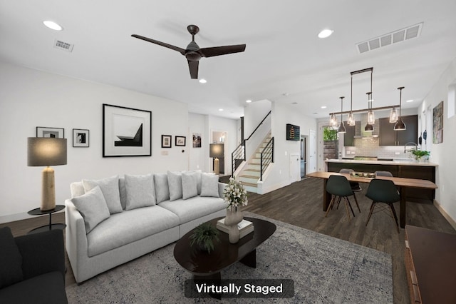 living room featuring wood-type flooring and ceiling fan