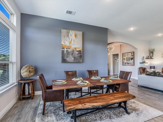 dining space featuring wood-type flooring and a chandelier