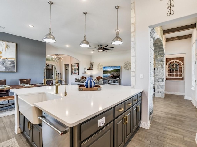 kitchen featuring beamed ceiling, ceiling fan, light hardwood / wood-style flooring, stainless steel dishwasher, and pendant lighting