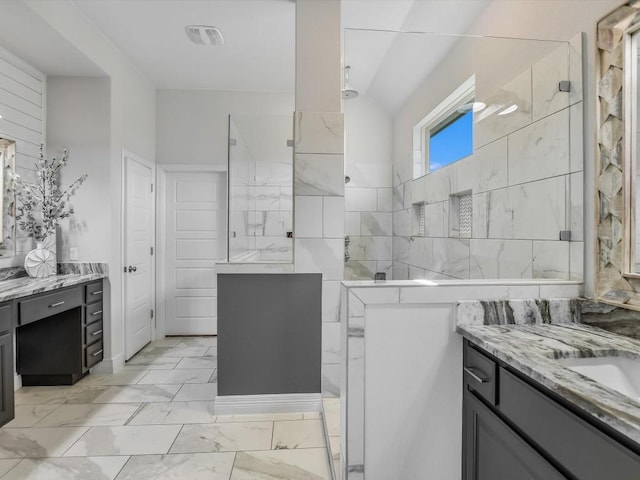 bathroom featuring tiled shower and vanity