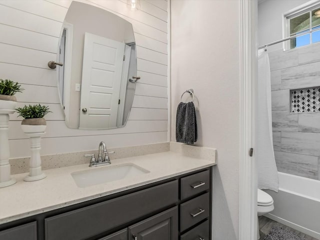 full bathroom with shower / tub combo, wooden walls, and vanity