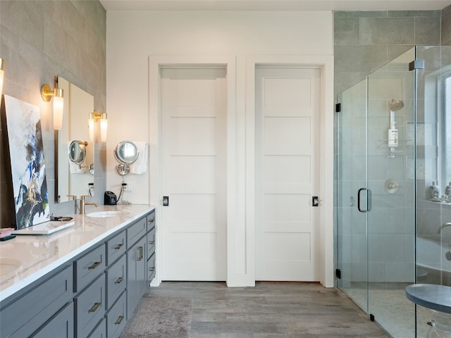 bathroom featuring vanity, an enclosed shower, and wood-type flooring