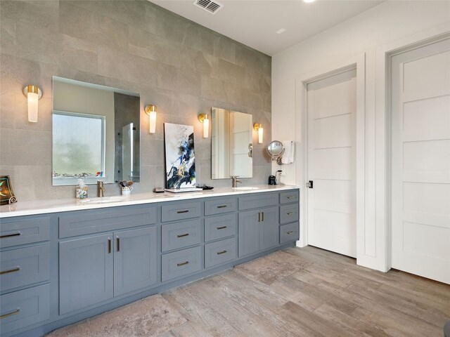 bathroom with decorative backsplash, wood-type flooring, and vanity