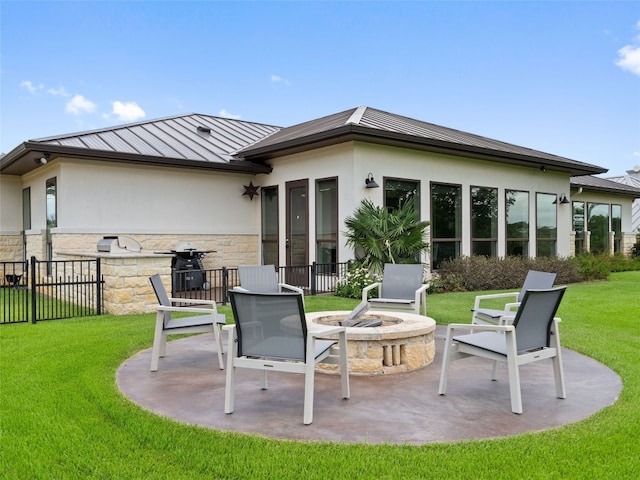 rear view of house with a yard, a patio, and a fire pit