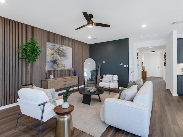 living room with ceiling fan and dark hardwood / wood-style flooring