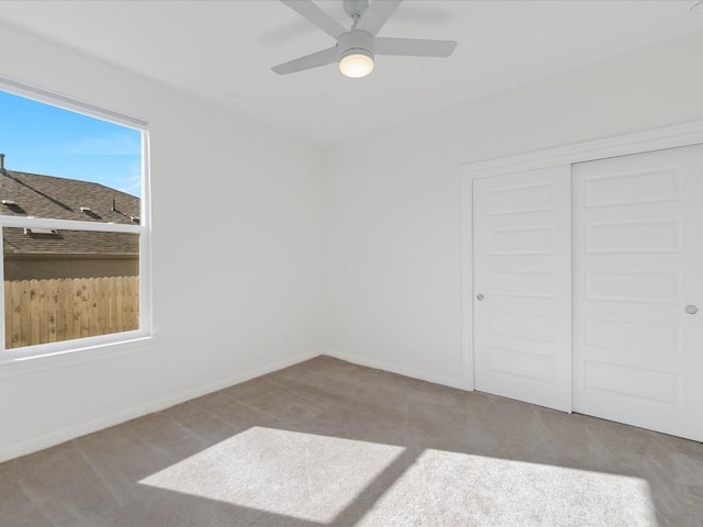 carpeted empty room featuring ceiling fan