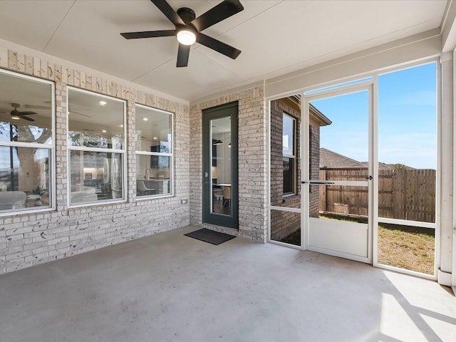 unfurnished sunroom featuring ceiling fan