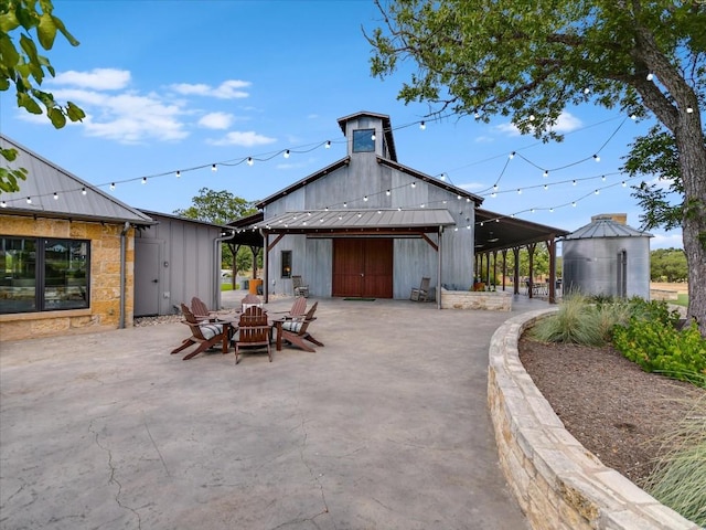 rear view of house with a fire pit and an outdoor structure