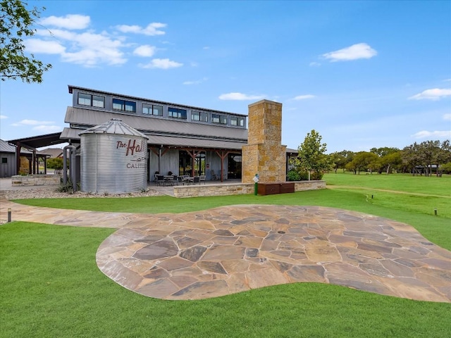 back of property with a lawn and a patio