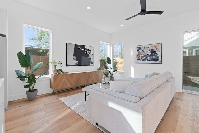 living room with ceiling fan, light hardwood / wood-style flooring, and a healthy amount of sunlight