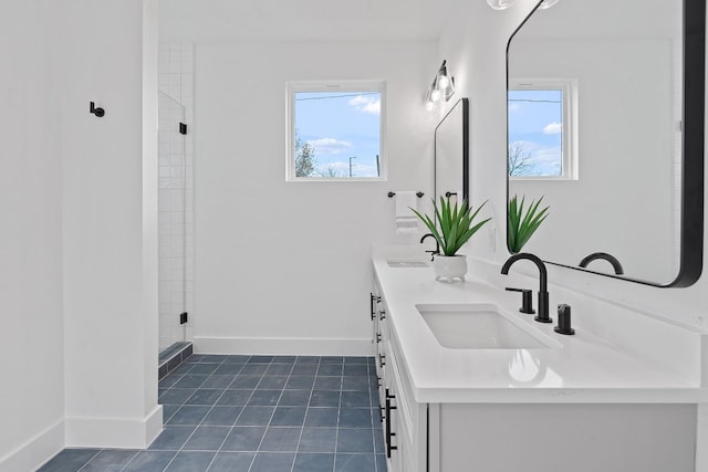 bathroom featuring vanity, a wealth of natural light, and a shower with shower door