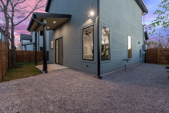 property exterior at dusk featuring a patio area