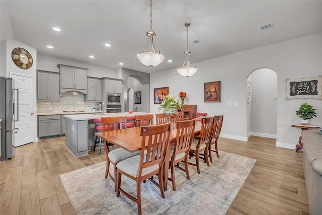 116 Berkeley Pl, Georgetown, TX 78628 - dining space featuring arched walkways, recessed lighting, and light wood-style floors
