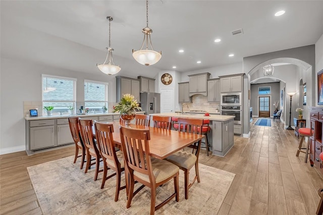 dining space featuring light wood-type flooring and sink