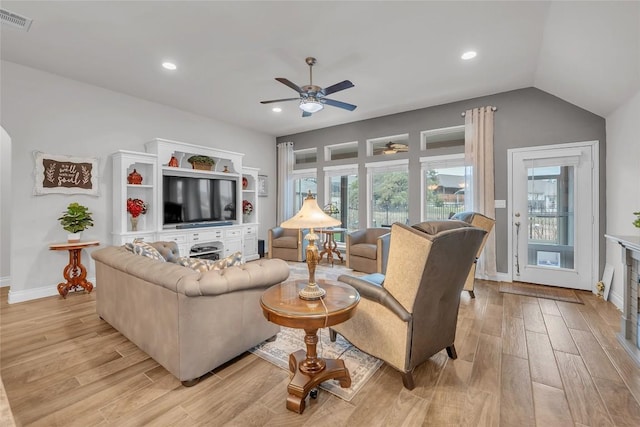 living room featuring ceiling fan, light hardwood / wood-style flooring, and vaulted ceiling