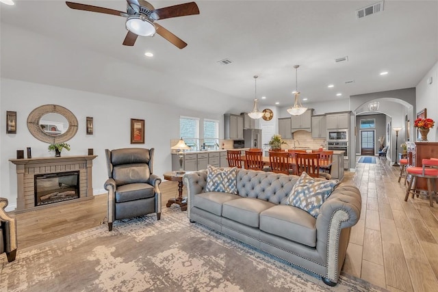 116 Berkeley Pl, Georgetown, TX 78628 - living area with ceiling fan, arched walkways, light wood finished floors, recessed lighting, and a brick fireplace