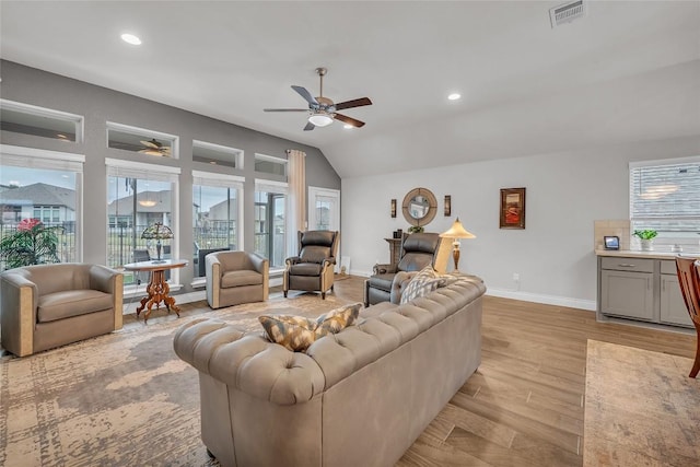 living room featuring ceiling fan, light wood-type flooring, and lofted ceiling