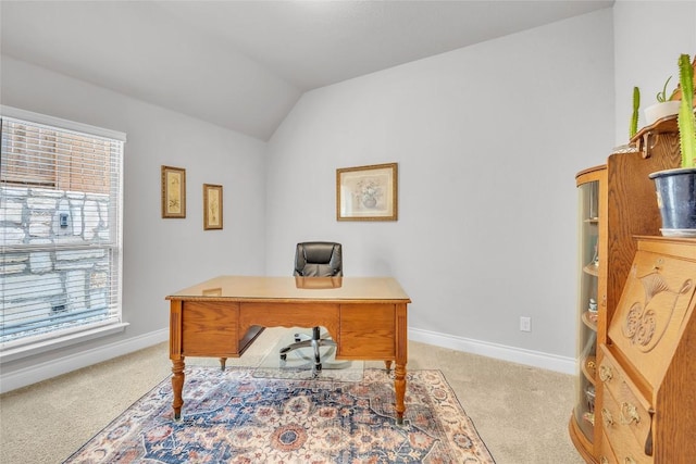 office featuring light carpet, vaulted ceiling, and a healthy amount of sunlight