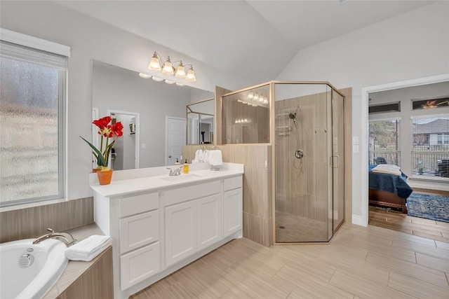 bathroom featuring vanity, a wealth of natural light, and lofted ceiling