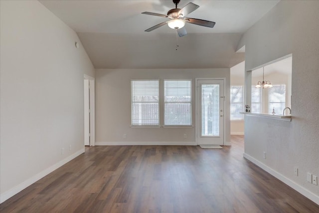 unfurnished room with ceiling fan with notable chandelier, dark wood-type flooring, and vaulted ceiling