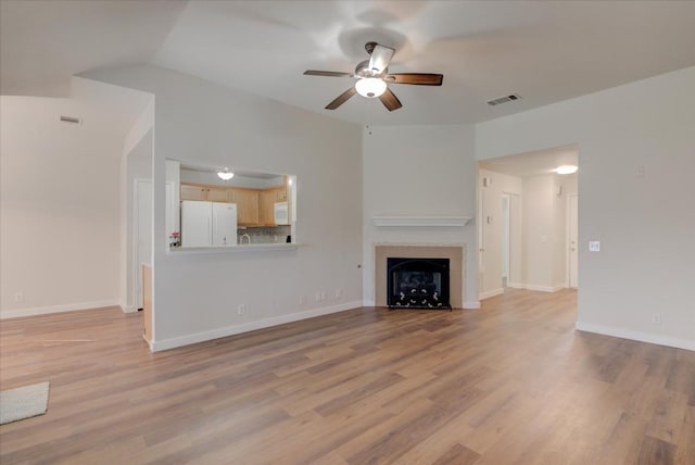 unfurnished living room featuring light wood-type flooring and ceiling fan