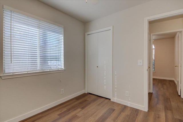 unfurnished bedroom featuring a closet and hardwood / wood-style floors