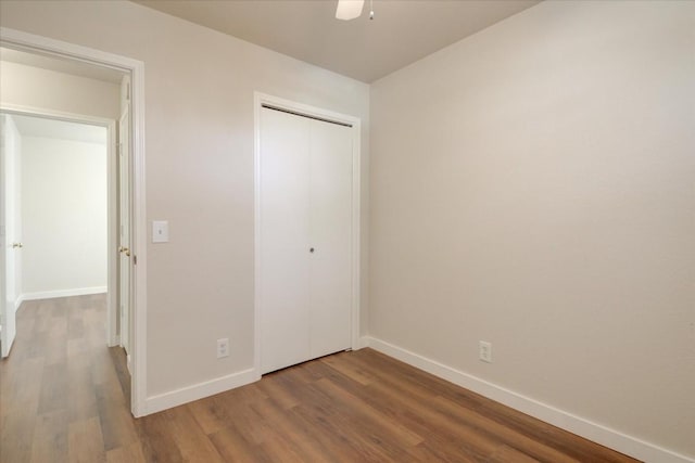 unfurnished bedroom featuring wood-type flooring, a closet, and ceiling fan