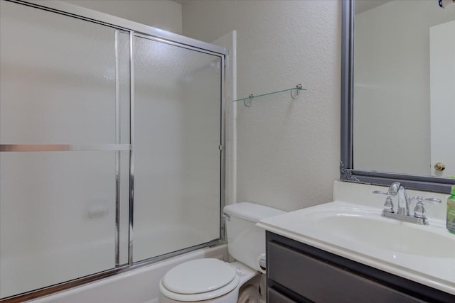 full bathroom featuring vanity, combined bath / shower with glass door, and toilet