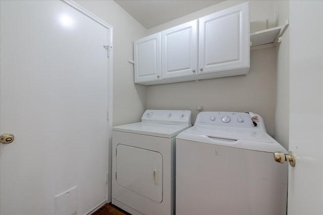 washroom with washer and dryer and cabinets