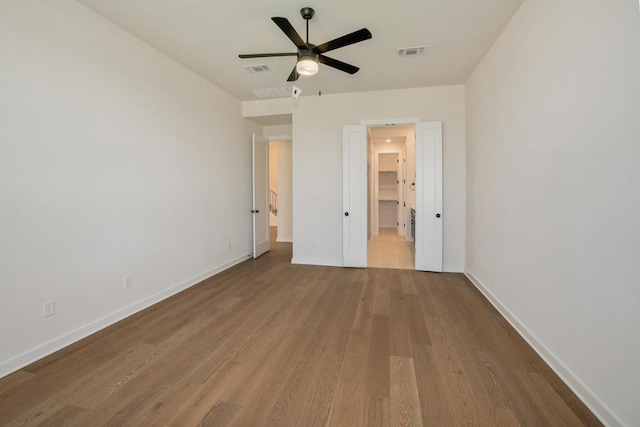 unfurnished bedroom featuring visible vents, baseboards, ceiling fan, and wood finished floors