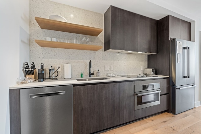 kitchen featuring sink, light hardwood / wood-style flooring, appliances with stainless steel finishes, tasteful backsplash, and dark brown cabinets