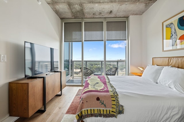 48 E Ave Unit 1607, Austin, TX 78701 - bedroom with a wall of windows, light wood-type flooring, and access to outside