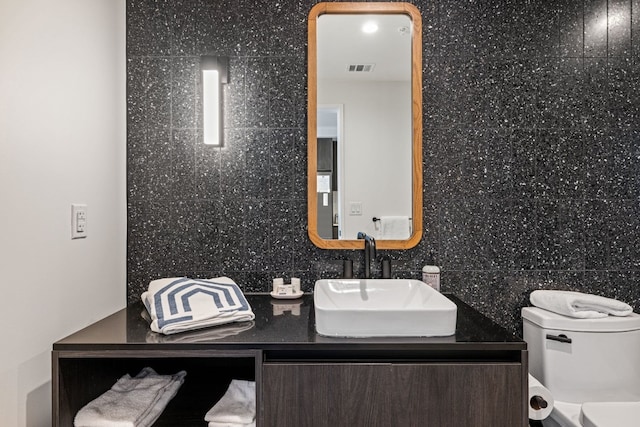 48 E Ave Unit 1607, Austin, TX 78701 - bathroom featuring toilet, vanity, and backsplash
