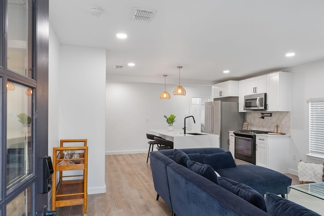 living room with sink and light hardwood / wood-style flooring