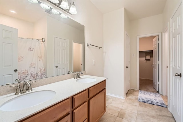 bathroom with tile patterned flooring, vanity, and walk in shower