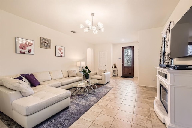 tiled living room with an inviting chandelier